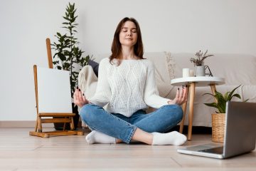 woman meditating with candles at home